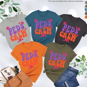 May include: Five t-shirts with the text "PEDS CREW" in a retro font. The shirts are in various colors, including grey, teal, dark grey, orange, and olive green. The text is in purple and orange.