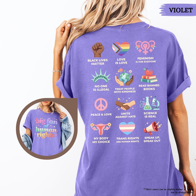 May include: A violet-colored t-shirt with various graphic designs and text promoting social justice and equality. The shirt includes phrases like "Black Lives Matter," "Love is Love," and "Feminism is for Everyone."