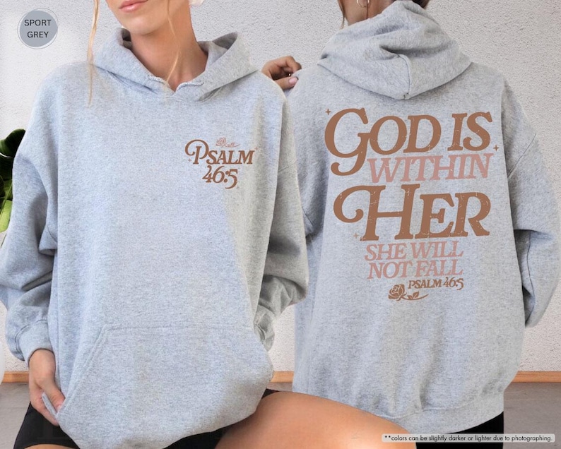 Puede incluir: Sudadera con capucha gris deportivo con el texto "PSALM 46:5" en la parte delantera y "GOD IS WITHIN HER SHE WILL NOT FALL PSALM 46:5" en la parte trasera. La sudadera tiene un bolsillo delantero y una capucha con cord&oacute;n.