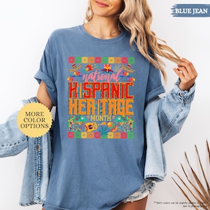 Peut inclure: T-shirt bleu jean avec l'inscription "national HISPANIC HERITAGE MONTH" dans un design color&eacute;. Le t-shirt pr&eacute;sente un motif festif avec des sombreros, des fleurs et d'autres &eacute;l&eacute;ments culturels. Le t-shirt est de style d&eacute;contract&eacute; et confortable.