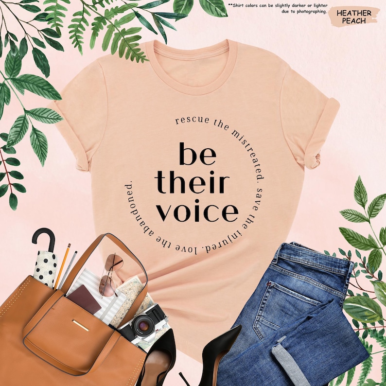 a t - shirt that says be their voice next to a handbag and purse