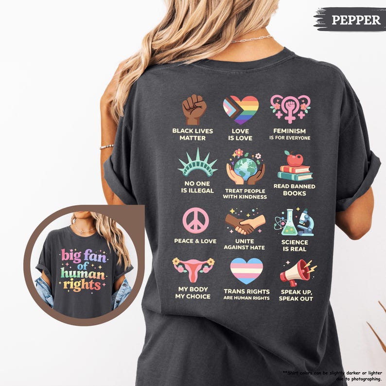 May include: Dark gray t-shirt with various social justice graphics, including a raised fist, a rainbow heart, and the text "Black Lives Matter." The shirt also features the text "big fan of human rights."