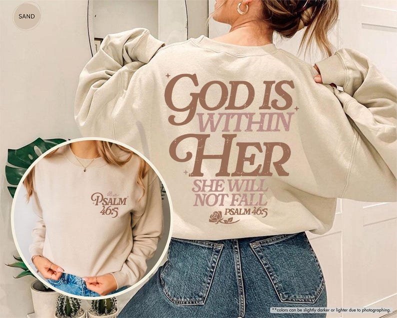 Puede incluir: Una sudadera de color arena con el texto "GOD IS WITHIN HER SHE WILL NOT FALL PSALM 46:5" en letras marrones y rosas. La sudadera tiene cuello redondo y mangas largas. Una imagen m&aacute;s peque&ntilde;a de la sudadera se muestra en un recuadro circular.