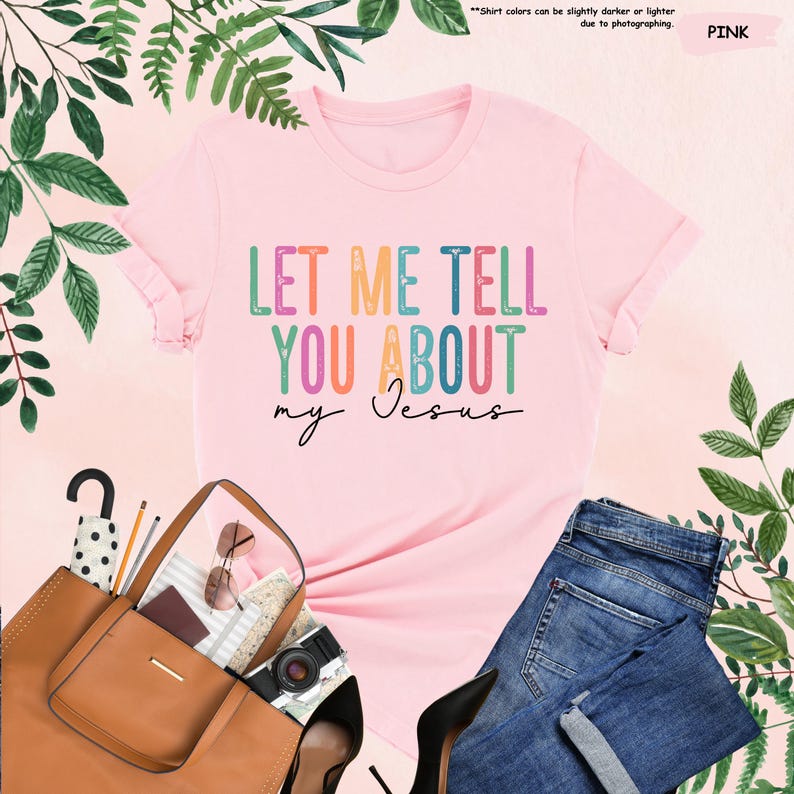 May include: Pink t-shirt with the text "LET ME TELL YOU ABOUT my Jesus" in rainbow colors.