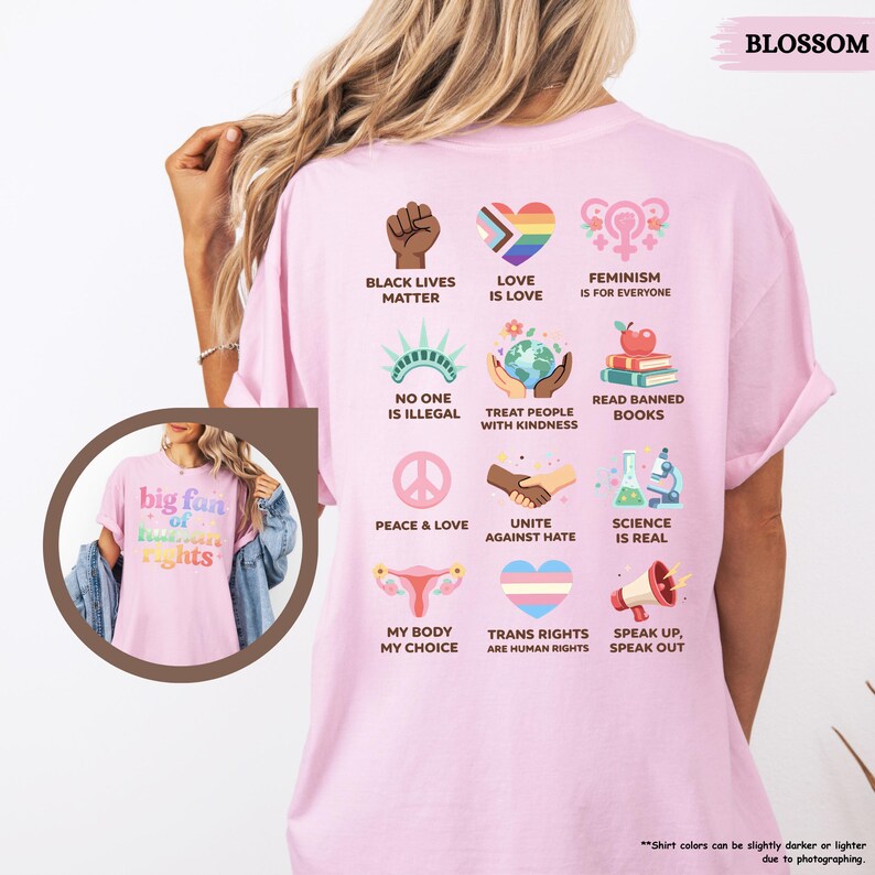 May include: A light pink t-shirt with various social justice icons and phrases printed on the back, including "Black Lives Matter," "Love is Love," and "Trans Rights are Human Rights." The front of the shirt features the text "big fan of human rights."