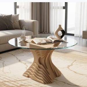 May include: A modern living room scene featuring a round glass coffee table with a unique, layered wooden base. A beige sofa, patterned rug, and decorative vase with a black accent are also visible. A cup of coffee and an open magazine rest on the table.