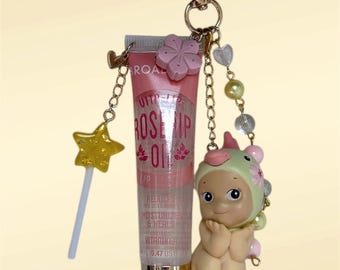 Llavero con dije y cuenta de brillo labial de loro en flor de cerezo de Sonny Angel