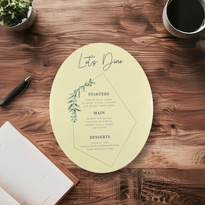 May include: A yellow oval-shaped menu with a green leafy design and the text "Let's Dine" at the top. The menu lists "Starters", "Main", and "Desserts" with a description of each dish.