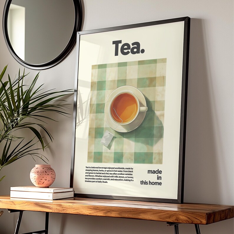 May include: A framed poster with a green and white checkered background. The poster features a cup of tea on a saucer, a tea bag, and the text "Tea. made in this home".