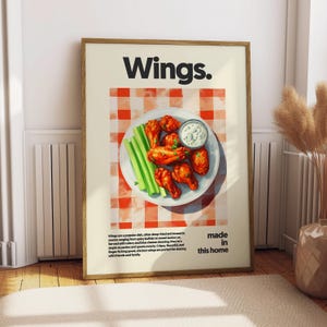 May include: A framed print featuring a plate of chicken wings, celery sticks, and dipping sauce. The background is a red and white checkered pattern. The word "Wings" is at the top, with "made in this home" at the bottom.