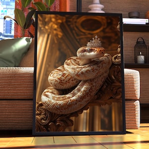 May include: A brown and white snake with a gold crown on its head is curled up on a gold ornate frame. The snake is in a framed picture.