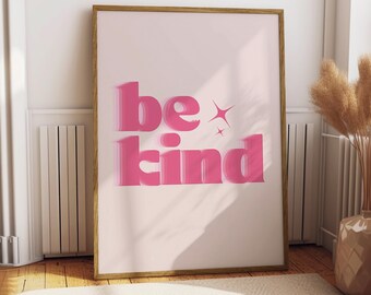 Può includere: Poster incorniciato rosa con il testo "be kind" in un font rosa 3D con stelle scintillanti su uno sfondo rosa chiaro.