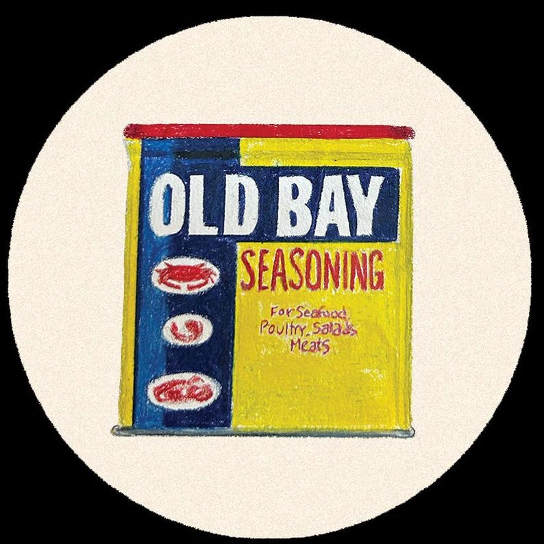 May include: A yellow and blue can of Old Bay Seasoning, with red accents. The label reads "OLD BAY SEASONING" in white letters, with the words "For Seafood, Poultry, Salads, Meats" below. The can is set against a cream-colored background.