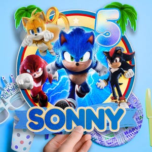 May include: A colorful birthday cake topper featuring Sonic the Hedgehog and friends. The design includes the number 5, the name "SONNY", and other party decorations. The characters are set against a blue background.
