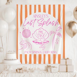 May include: A white and orange striped banner with the text "Ainsley's Last Splash" in pink. The banner features a mermaid illustration, a disco ball, and the words "Palm Springs, California". White balloons and a cake are in the background.