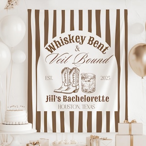 May include: White and brown striped backdrop with the text "Whiskey Bent & Veil Bound" in a brown arch. The text "Est. 2025" is below the arch. The text "Jill's Bachelorette Houston, Texas" is below the arch. There are two brown cowboy boots and a glass of whisky in the centre of the arch.