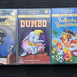 May include: Three Walt Disney Collection VHS tapes: "Pinocchio," "Dumbo," and "Bedknobs and Broomsticks." Each tape features colourful artwork of the characters and titles. The tapes are in plastic cases, with the Disney logo at the top.