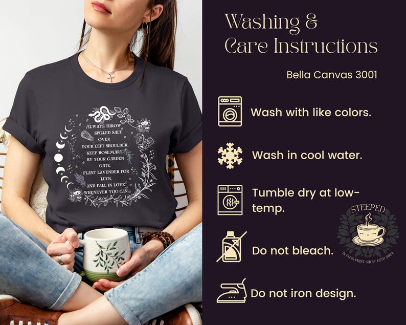 May include: A black t-shirt with a white graphic design featuring a circle with a snake, moon phases, and text that reads "Always throw spilled salt over your left shoulder, keep rosemary by your garden gate, plant lavender for luck, and fall in love whenever you can". The image also includes washing and care instructions for Bella Canvas 3001 shirts, including washing with like colors, washing in cool water, tumble drying at low temperature, not bleaching, and not ironing the design.