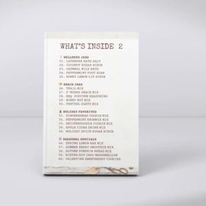 May include: A white rectangular card with the heading WHAT'S INSIDE 2. It lists items under four categories: WELLNESS JARS, SNACK JARS, HOLIDAY FAVORITES, and SEASONAL SPECIALS, numbered 21 through 40, with small icons next to each category title.