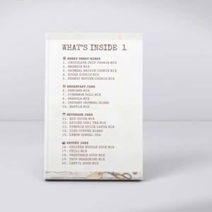 May include: A rectangular white card featuring the heading WHAT'S INSIDE 1 in brown text. The list includes Sweet Treat Mixes, Breakfast Jars, Beverage Jars, and Savory Jars, numbered 1 through 20 with various food mix names printed in brown.