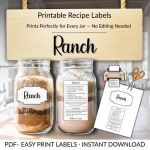 Puede incluir: Imagen de etiquetas de recetas imprimibles para tarros. Las etiquetas dicen "Ranch" e incluyen una receta. Dos tarros están llenos de ingredientes. También se muestra una etiqueta impresa y un par de tijeras.