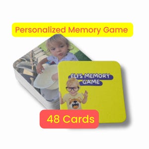 Peut inclure: Un jeu de mémoire personnalisé avec 48 cartes. Le jeu présente une pile de cartes carrées avec une photo d'un enfant d'un côté et une carte jaune avec le texte "Eli's Memory Game" et une photo d'un enfant portant des lunettes.