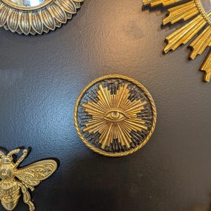 decoration murale avec symbole illuminati du soleil avec l'oeil à l'interieur. Medaillon type ex voto