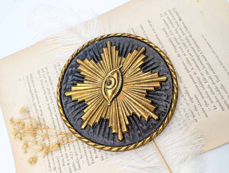 decoration murale avec symbole illuminati du soleil avec l'oeil à l'interieur. Medaillon type ex voto