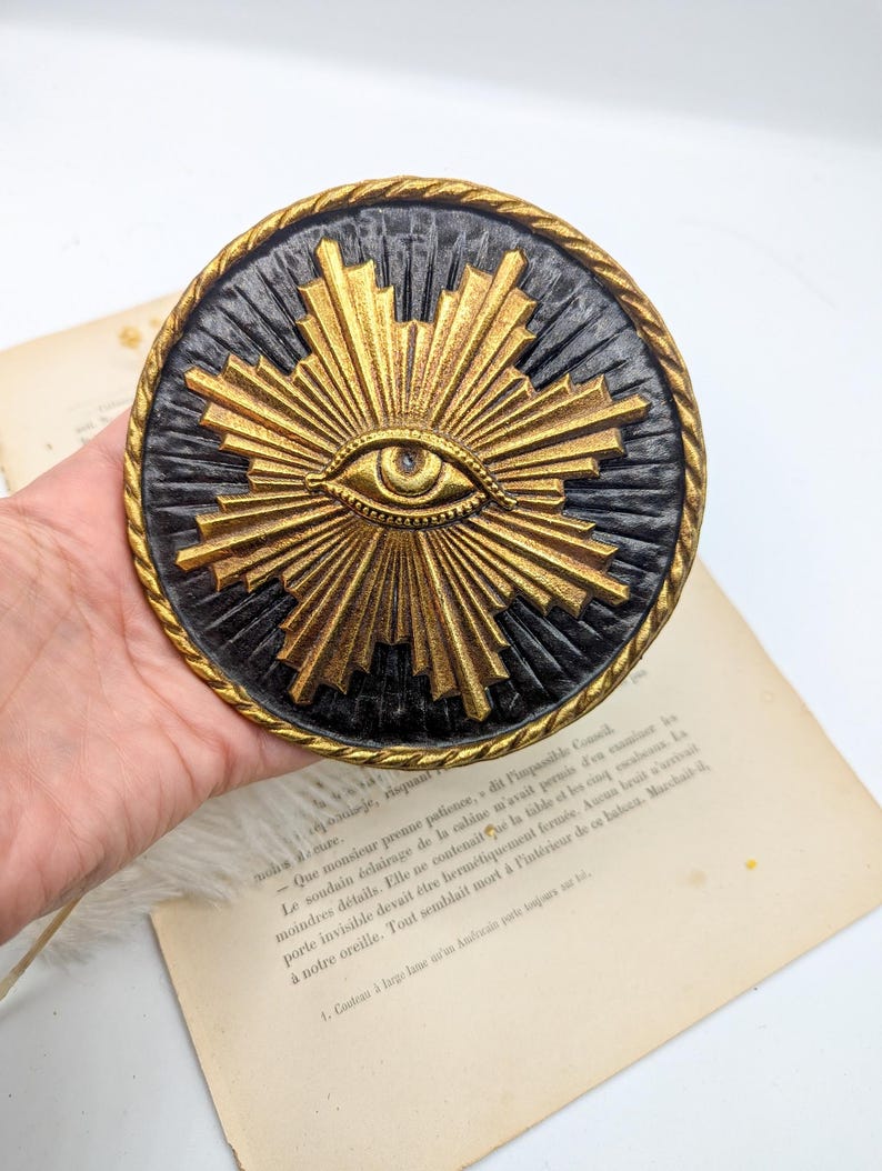 decoration murale avec symbole illuminati du soleil avec l'oeil à l'interieur. Medaillon type ex voto