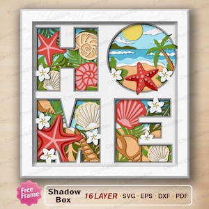 May include: A square white shadow box frame containing a multi-layered paper craft design spelling the word HOME. Each letter features tropical beach elements including red starfish, various tan and pink seashells, green palm leaves, and white flowers.