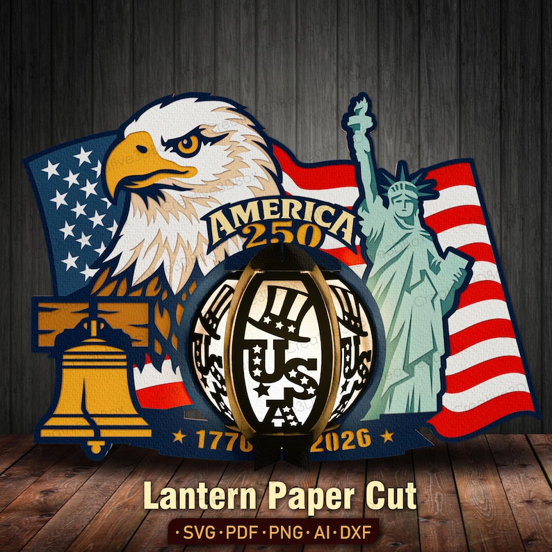 K&ouml;nnte beinhalten: Ein patriotisches Papierschnittdesign mit einem amerikanischen Wei&szlig;kopfseeadler, der Freiheitsstatue und einer US-Themenlaterne. Das Design umfasst die amerikanische Flagge, die Liberty Bell und den Text "AMERICA 250" und "1776-2026". Die Laterne hat den Text "US" und Sterne.