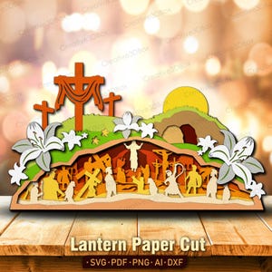 May include: A multi-layered paper cut scene with religious imagery, including crosses, figures, and a tomb. The design incorporates a cross on a hill, a rising sun, and white lilies. The text "Lantern Paper Cut" is at the bottom.