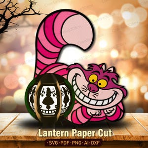May include: A paper cut design featuring the Cheshire Cat from Alice in Wonderland, with a lantern and the text "Lantern Paper Cut". The cat is pink and purple with a wide grin. The lantern is black with white cutouts.