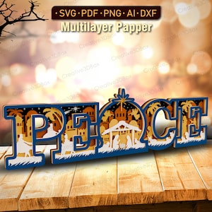 May include: A layered wooden sign spelling "PEACE" with a nativity scene and star design. The sign is blue, white, and tan, and sits on a wooden surface. The sign is a multilayer paper design.