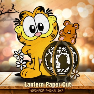 Puede incluir: Un gato amarillo de dibujos animados con un diseño de farolillo de papel recortado. El farolillo tiene una silueta del gato y un pequeño osito de peluche encima. El texto "Lantern Paper Cut" está en la parte inferior.