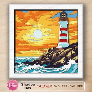 May include: A multi-layered paper shadow box art piece featuring a lighthouse with red and white stripes on a rocky cliffside. The scene includes a bright yellow and orange sunset sky with a pale sun and blue ocean waves crashing against rocks.