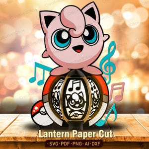 Puede incluir: Un diseño recortado en papel con un personaje de dibujos animados rosa con grandes ojos azules, posado sobre una linterna. La linterna tiene un diseño negro y dorado con notas musicales y una silueta de personaje. También se incluyen notas musicales y una Pokéball adicionales.