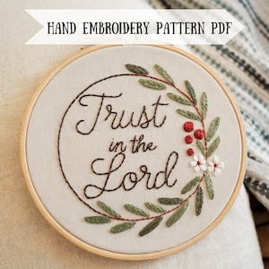 Könnte beinhalten: Stickrahmen-Kunst mit einer grünen Blätterkrone und dem Schriftzug "Trust in the Lord" in Kursivschrift.