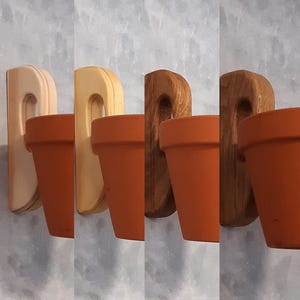 Peut inclure: Ensemble de quatre pots en terre cuite avec supports muraux en bois. Les supports en bois varient en couleur, du brun clair au brun foncé. Les pots en terre cuite sont d'un brun-orangé chaud et sont conçus pour les plantes.