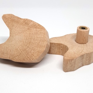 Può includere: Due tiretti per cassetti in legno a forma di testa di gatto non finiti. I tiretti sono a forma di testa di gatto con un foro nella parte superiore per una vite. I tiretti sono in legno marrone chiaro.