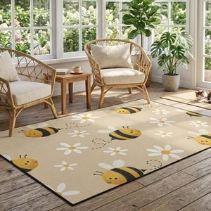 May include: A rectangular area rug featuring a repeating pattern of cartoon bees with yellow and black stripes and white daisy flowers on a light beige background. The rug has a clean, finished edge and is positioned on a wooden floor.