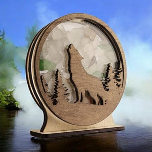 May include: A wooden silhouette of a wolf howling at the moon, surrounded by a circle of white and green sea glass. The silhouette is mounted on a wooden base.