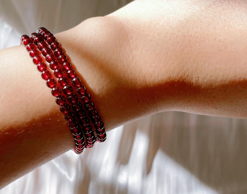 May include: A red beaded bracelet with multiple strands of small, round beads.