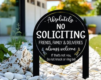 May include: A black, round, metal garden sign with white text that reads: Absolutely NO SOLICITING, FRIENDS, FAMILY & DELIVERIES always welcome, If that's not you, Do not knock or ring bell. The sign features two stakes and decorative leaf accents.