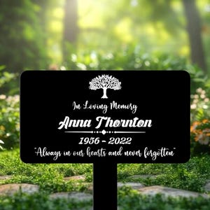 Może przedstawiać: Czarny metalowy znak pamiątkowy z białą sylwetką drzewa, tekst "In Loving Memory Anna Thornton 1956-2022 "Always in our hearts and never forgotten"