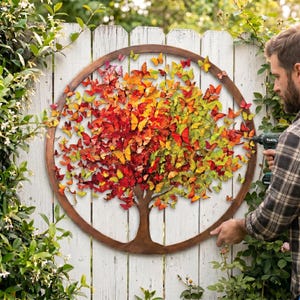 May include: A circular metal wall art piece featuring a tree silhouette filled with numerous small, three-dimensional butterflies in a gradient of colors ranging from deep red and orange on the left to bright yellow and green on the right.