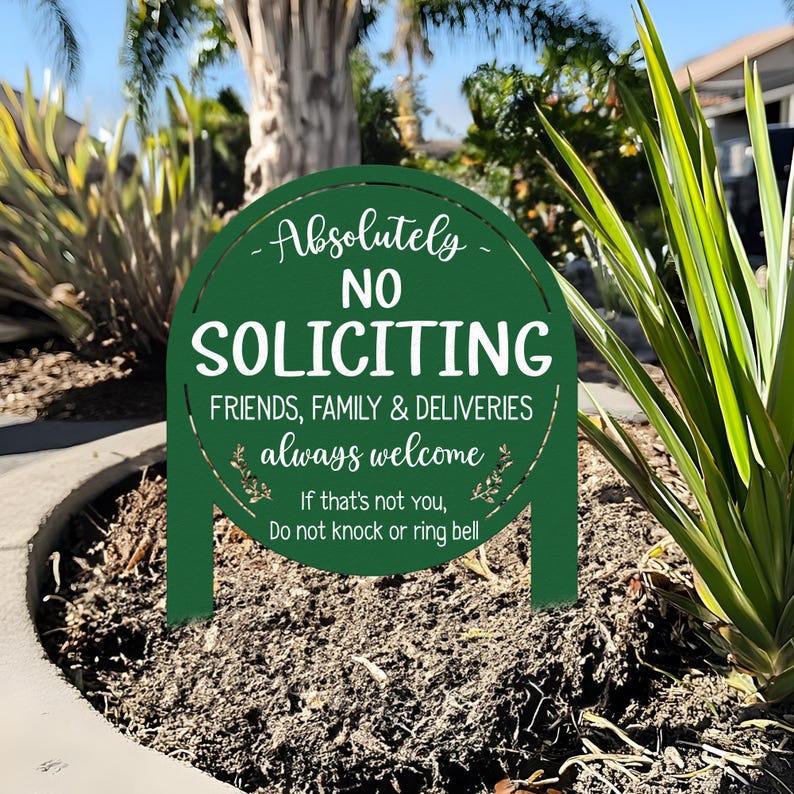 May include: A dark green, round, arched yard sign with white text that reads: Absolutely NO SOLICITING, FRIENDS, FAMILY & DELIVERIES always welcome, If that's not you, Do not knock or ring bell. The sign features two stakes for ground insertion.