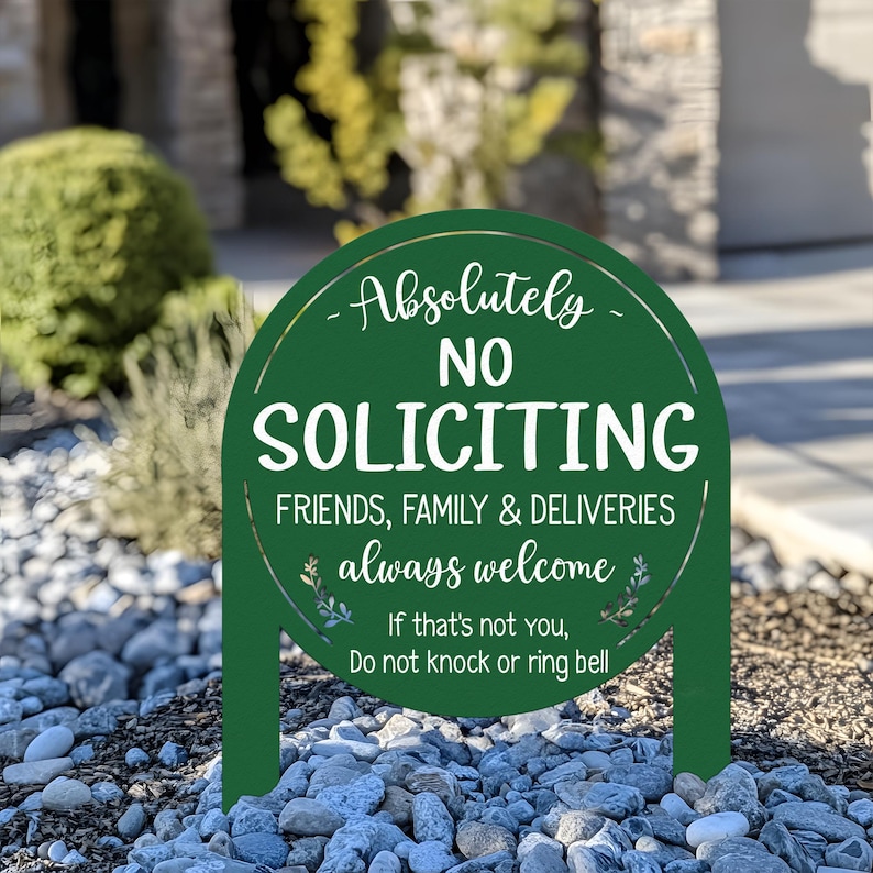 May include: A dark green circular metal yard sign with white text that reads Absolutely NO SOLICITING FRIENDS, FAMILY & DELIVERIES always welcome. If that's not you, Do not knock or ring bell. The sign features two stakes at the bottom.