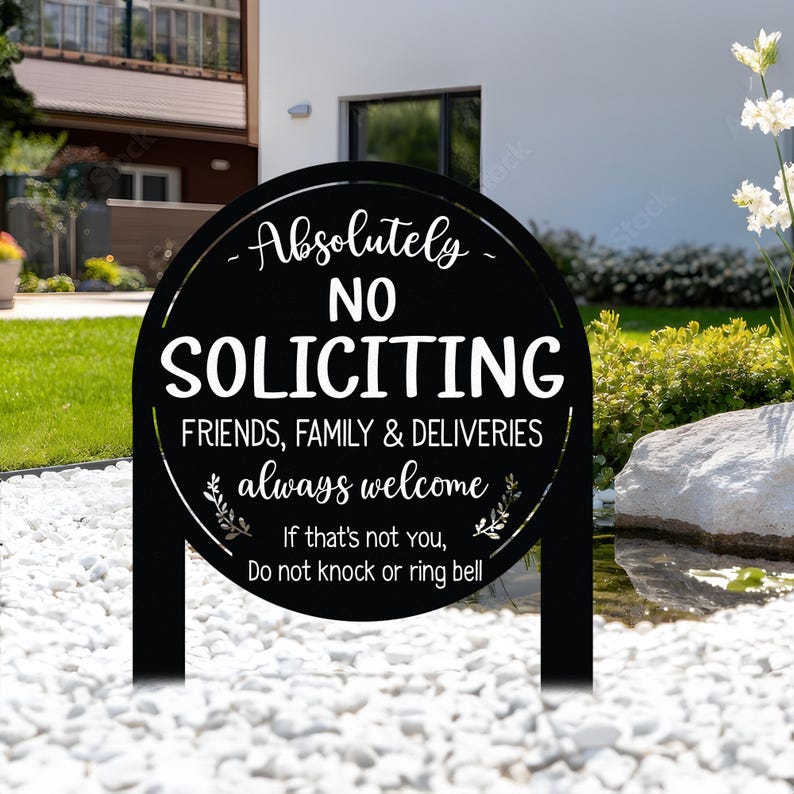 May include: A round black metal yard sign with white text that reads: Absolutely NO SOLICITING, FRIENDS, FAMILY & DELIVERIES always welcome, If that's not you, Do not knock or ring bell. The sign features two small leaf branch icons.
