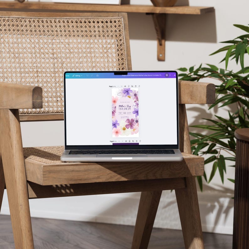 K&ouml;nnte beinhalten: Ein Laptop-Computer, auf dem eine digitale Einladung mit einem Blumendesign angezeigt wird. Die Einladung lautet "Mother's Day Brunch" mit Datum und Uhrzeit. Der Laptop steht auf einem Holzstuhl.
